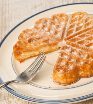 Sweet waffle on a rustic plate in a kitchen