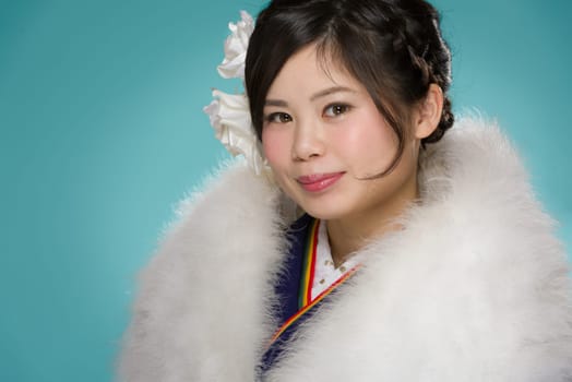 A portrait of a beautiful young Japanese girl in a blue kimono for her coming of age ceremony on her 20th birthday.
