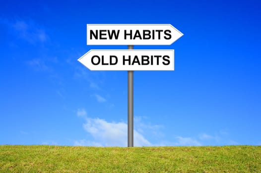 Signposts on a meadow in front of a blue sky shows Old Habits or new Habits