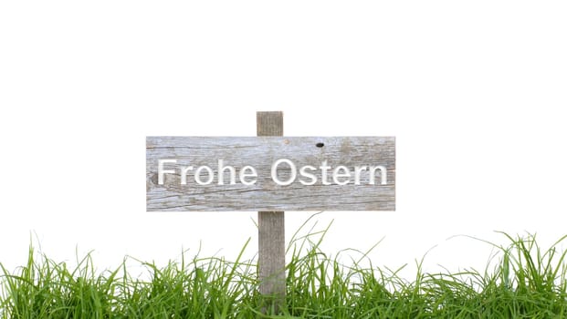 Old wooden sign behind green grass shows Happy Easter
