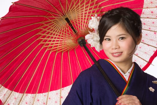 A portrait of a beautiful young Japanese girl in a blue kimono for her coming of age ceremony on her 20th birthday.