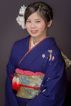 A portrait of a beautiful young Japanese girl in a blue kimono for her coming of age ceremony on her 20th birthday.