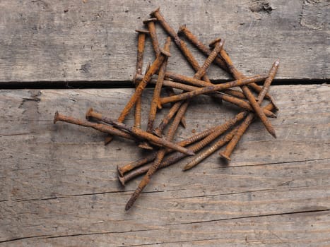 Rusty nails on an old wooden background