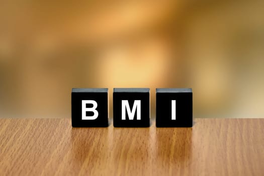 BMI or Body Mass Index on black block with blurred background