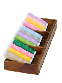 Collection of colorful threads in a wooden box