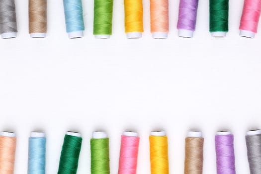 colorful spool of threads on white background