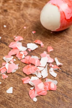 Red eggshells and Easter egg on a wooden board