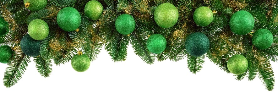 Decoration of fresh fir branches with green Christmas balls on a white background