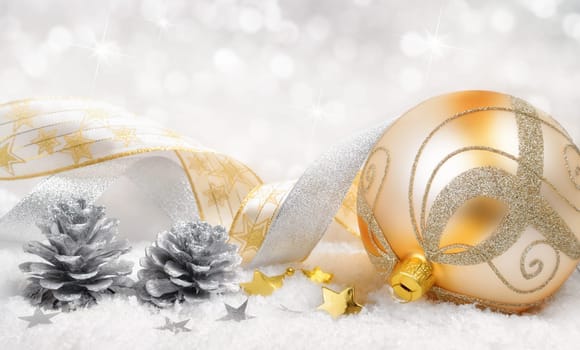 Dreamy Christmas arrangement with golden ball,decobe bands and pine cones on snow