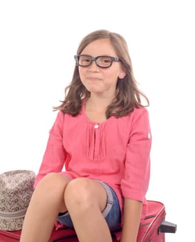 girl sitting on a suitcase is happy to go on holiday