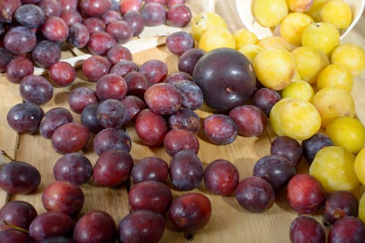 red and yellow plums on a wooden table