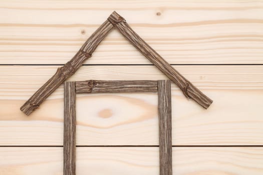 small house made of branches on wood background