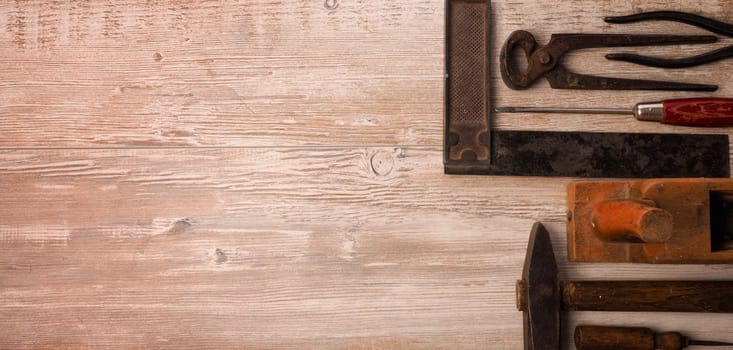 Old used wood worker tools on a wooden table with space for text or image