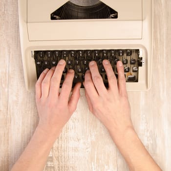 Male hand on a vintage typewriter, top view