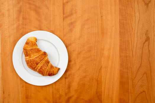 delicious croissant on wooden table from above