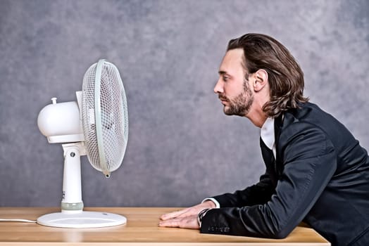 young business man in dark suit sitting in front of ventilator
