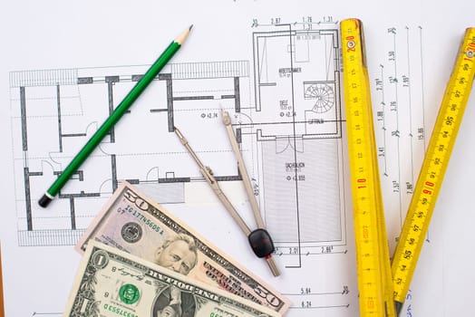 building plan with money pencil folding yardstick and compass