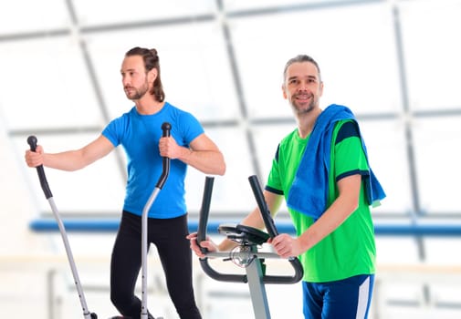 two young man train with fitness machine