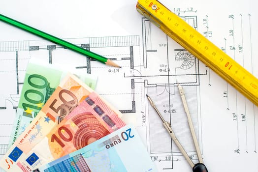 building plan with money pencil folding yardstick and compass