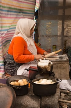 Gilan Province- North of  IRAN-December ‎19, ‎2014- A Woman Working As A Breadwinner, Who Bbake Traditional Bread And Serving Tea And Boiled Eggs For Passengers In The Bank Of Street For Little Income.
