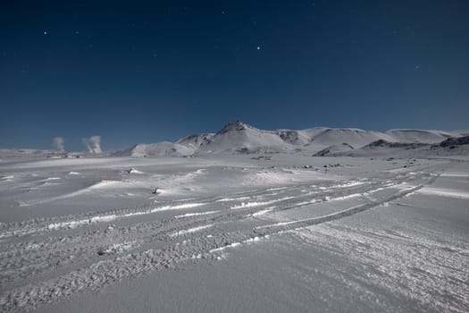 Starry sky over snow covered mountains in the wintertime