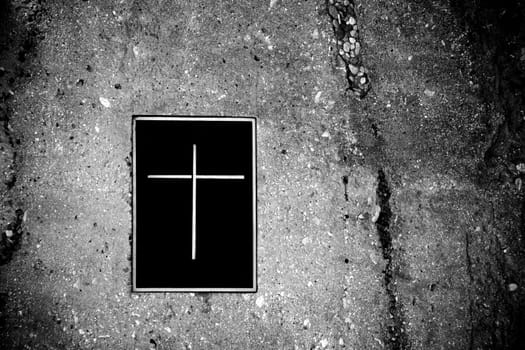 A grave embedded in rocks with a lid or closure with a cross symbol.