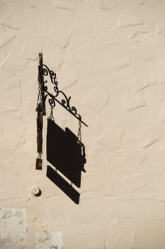 A nostalgic trailer of a shop casts a shadow on a wall plastered with structure.
