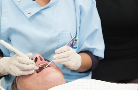 Visiting the dentist having a checkup, clean and work done. Close up images of the dentist working on and in a mouth