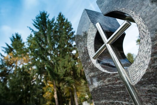 Cross and tombstone with trees in a cemetery