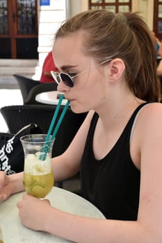 a teenager at the resort in Croatia drinks a non-alcoholic cocktail