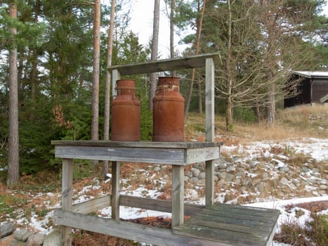 two old rusty milk jug on a bench like a beutiful ornament
