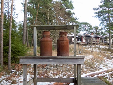 two old rusty milk jug on a bench like a beutiful ornament