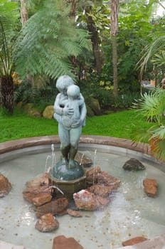 one antique female statue and a fountin with water