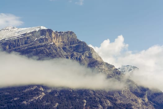 Close up of the snow capped peak of Grotto Mountain with a cloud.