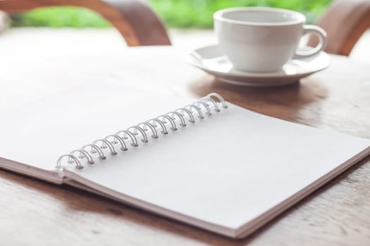 Open blank white notebook with cup of coffee, stock photo