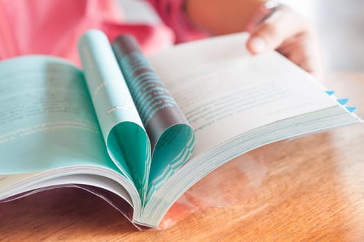 Woman reading book in coffee shop, stock photo