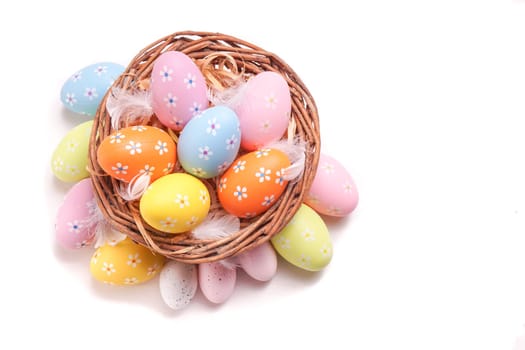 Colorful Easter eggs gathered in a basket, isolated on white