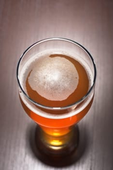 Close-up of a beer glass with foam on the table