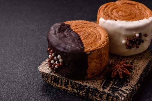 Round sweet New York roll croissant with chocolate cream filling on a dark concrete background