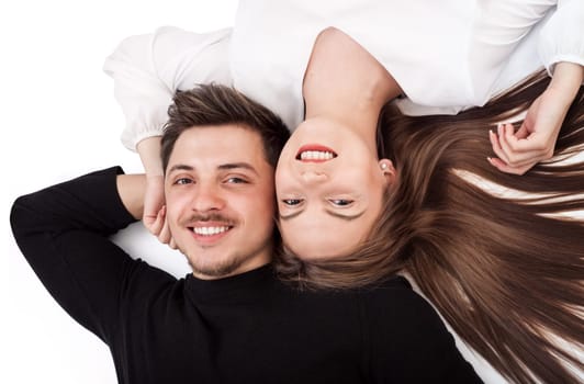 Happy young couple lying down on their back together