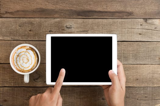 hand using mock up tablet on wood desk with clipping path display easy add element