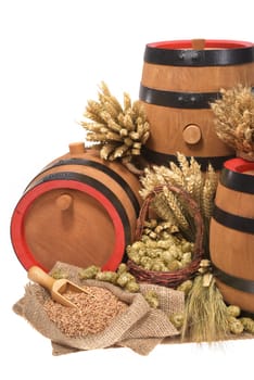 three old beer barrels insulated with wheat,barley,hops and malt On White