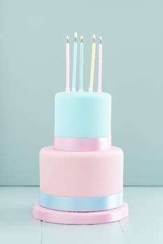 Fondant covered pastels coloured birthday cake with five birthday candles