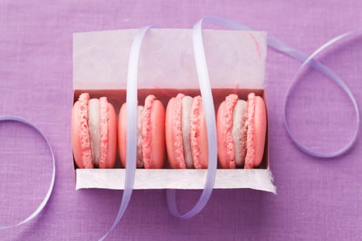 Pink macarons with buttercream filling in a box