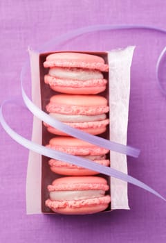 Pink macarons with buttercream filling in a box