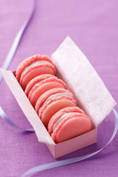 Pink macarons with buttercream filling in a box