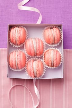 Pink macarons with buttercream filling in a box