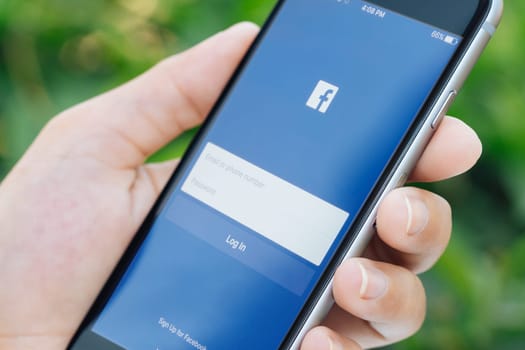Bangkok, Thailand - feb 23, 2016 : Closeup hand using facebook social network application connect to people on phone, Facebook app developed by Facebook Inc.