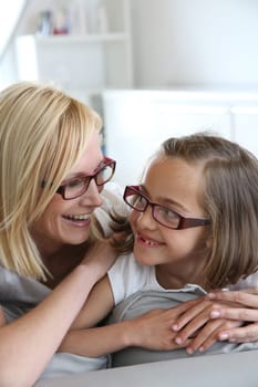 Mom and little girl sitting in sofa