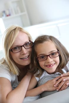Mom and little girl sitting in sofa